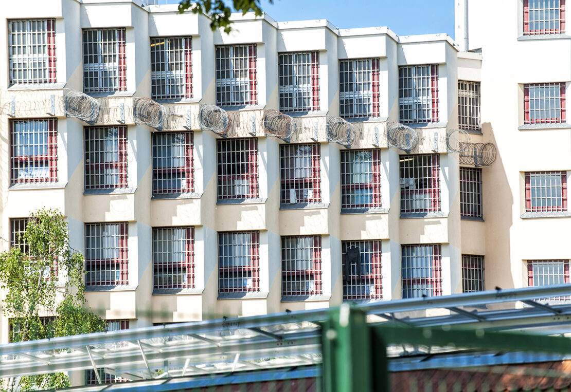 mehrstöckiges weißes Haus mit Gittern vor den Fenstern